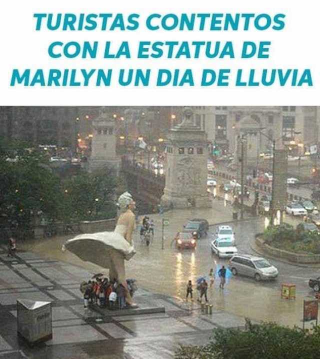 Turistas contentos con la estatua de Marilyn un día de lluvia.